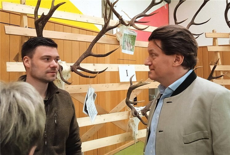Vorsitzender Christian Möller (rechts) vor der Ehrentafel im Gespräch mit einem Jäger.  Foto: GS