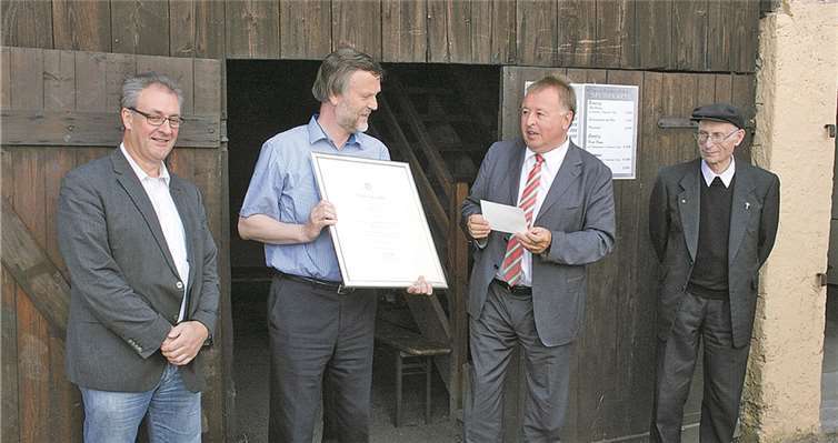 Vorsitzender Manfred Weiland erläuterte Landrat Dr. Pföhler (Bildmitte) und Ortsbürgermeister Felten bei einer Führung die Details der Wohnstube.WK