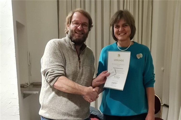 Vorsitzender Timo Müller gratuliert Anje Hamann-Kraut zur goldenen Ehrennadel des Deutschen Imkerbunds.