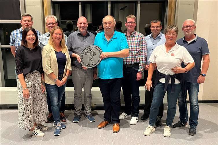 Vorstand der AKK mit Erich Thönnes im Vordergrund. Sein Abschiedsgeschenk: Ein Kanaldeckel mit Schängel-Emblem. Foto: Frank Behr