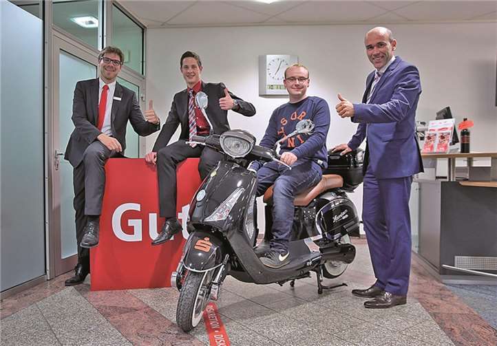 Vorstandsmitglied Guido Mombauer (re.), Geschäftsstellenleiter Christian Frings (li.) und Kundenberater Andreas Bell (2.v.l.) wünschten dem Gewinner Martin Baur (2.v.r.) mit seinem neuen Elektro-Roller allzeit gute Fahrt.KSK AW
