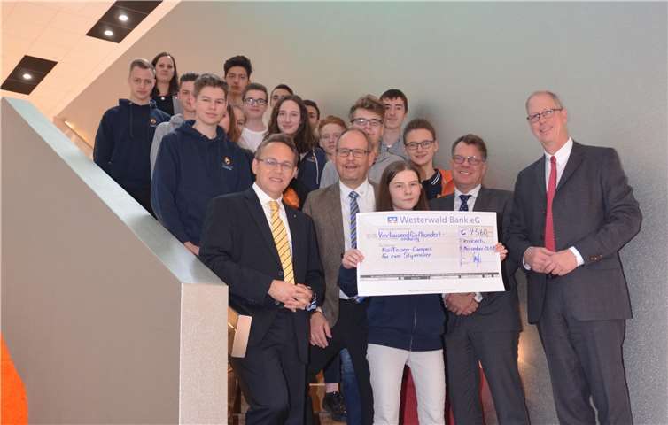Vorstandssprecher Wilhelm Höser und sein Vorstandskollege Dr. Ralf Kölbach übergaben den symbolischen Scheck an Schulleiter Bernhard Meffert und Dr. Jörn-Peter Kukuk vom Vorstand der Genossenschaft sowie Vertreter der Lernerinnen und Lerner. privat