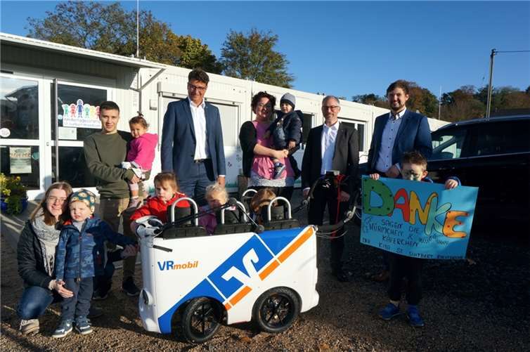 Vorstandssprecher der VR Bank Rhein-Mosel eG, Matthias Herfurth (2. v.r.), Christian Kehr (Mitte), Bereichsleiter Regionalmarkt Rhein und Sebastian Jacke (rechts), Teamleiter in Bad Hönningen bei der Übergabe eines Kinderbusses in der Kita in Rheinbrohl.