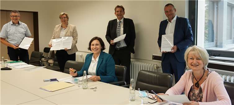 Während der Vertragsunterzeichnung: v.li. Hans Dieter Wirtz, Petra Kalkbrenner, Claudia Müller-Bück und Sabine Schröder (1.v.r.) von der Evangelischen Kirchengemeinde Swisttal, Achim Konitz von der Evangelischen Axenfeld Gesellschaft gGmbH und Herr Jens Holdt (2.v.r.) von der KJF- Gemeinnützige Ev. Gesellschaft für Kind, Jugend und Familie mbH..Quelle: Gemeinde Swisttal