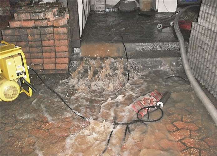 Während der Wasserschlamm aus dem Hauseingang von Stefan Reudelsterz schoss, arbeiteten die Pumpen der Feuerwehr auf Hochtouren.