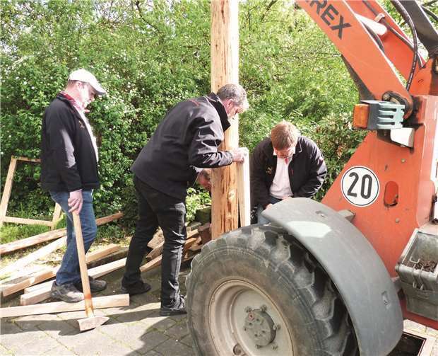 Während der große Maibaum mit Hilfe eines Gabelstaplers in den Schacht bugsiert wurde, sicherten die Prinzengardisten den Stamm mit vielen Holzkeilen.