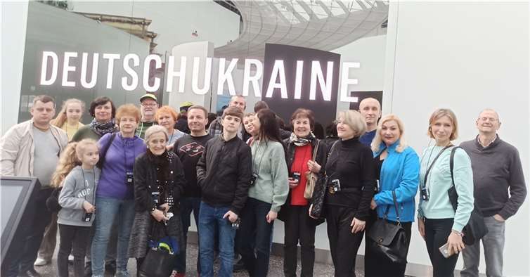 Während die ukrainischen Gastkinder noch an den interaktiven Informationsständen spielten, stellten sich die Eltern unter der eigens generierten Leuchtschrift zu einem gemeinsamen Erinnerungsbild auf.  Foto: privat