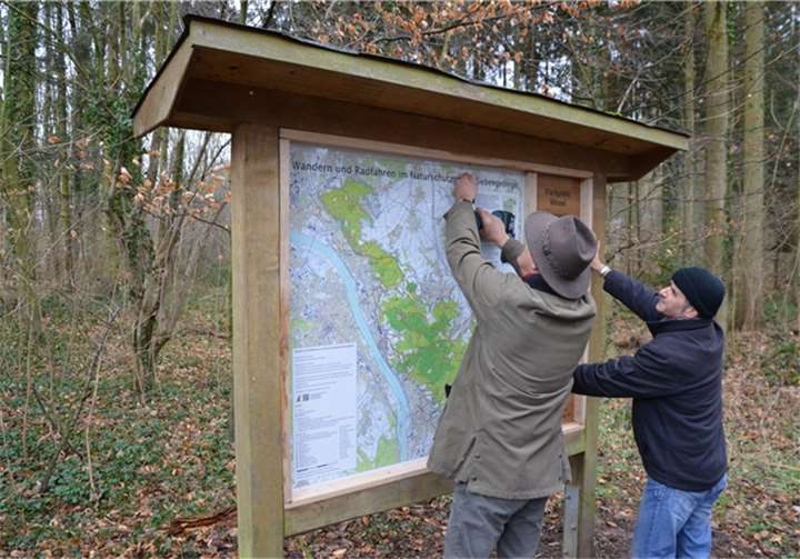 Waldemar von Lewin von der Firma Induflex, Bad Honnef, mit einem Mitarbeiter bei der Befestigung der Wandertafel.  Pressestelle Rhein-Sieg-Kreis