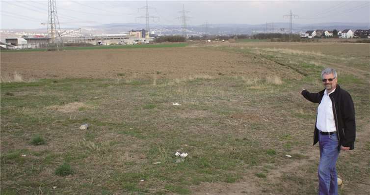 Walter Baum (FBG) zeigt auf den bereits markierten Verlauf des zweiten Baubschnitts der Ortskernentlastungsstraße. Im Hintergrund sind der im Bau befindliche Globus-Markt und die Arbeiten am ersten Bauabschnitt zu erkennen. privat