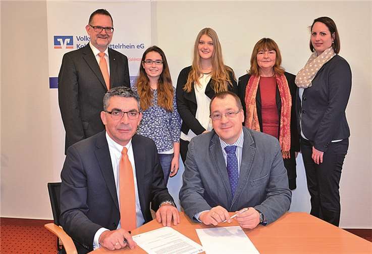 Walter Müller, Vorstand Volksbank Koblenz Mittelrhein (vorne links) und Schulleiter Hans-Georg Meier (vorne rechts) besiegelten die erste Schülergenossenschaft in Koblenz gemeinsam mit (v. hinten l.) Werner Birkenheier, Prokurist Volksbank Koblenz Mittelrhein, den Schülerinnen Lea Rieser und Lena Stoerk und den Lehrerinnen Brigitte Balzer-Engel und Christina Becker. Auf dem Bild fehlt Judith Sauerborn, Marketingleiterin der Volksbank.