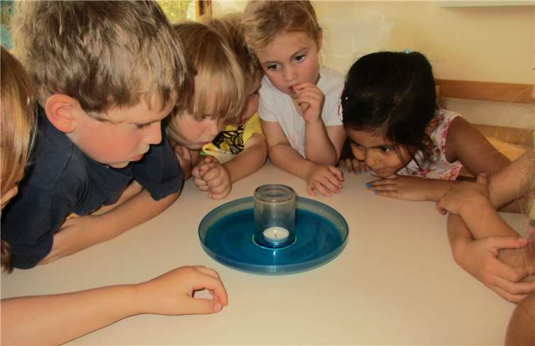 Wasserforscher bei der Arbeit „Warum steigt das Wasser im Glas, wenn da das Teelicht brennt?“.