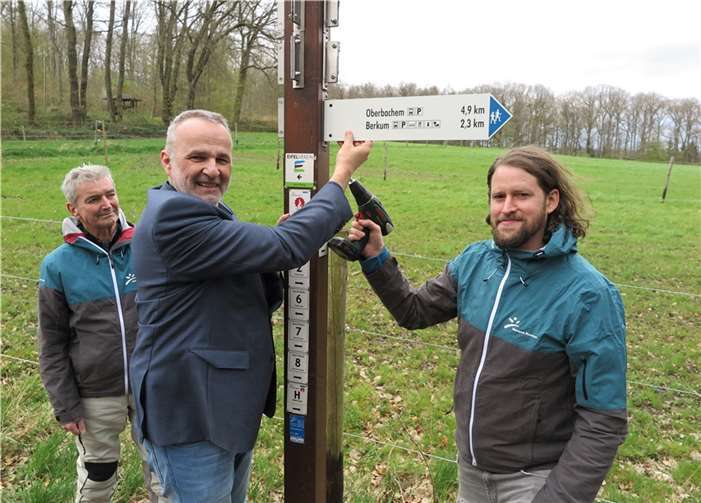 Wegeleitsystem: Harald Sauer (li.) und Dominik Liebenstein (re.) vom Naturpark Rheinland mit Bürgermeister Jörg Schmidt, der bei der Reparatur des Wegweisers mit anpackte. Foto: Gemeinde Wachtberg/mm
