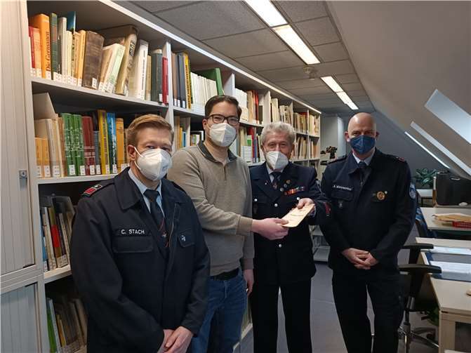 Wehrführer Carsten Stach, Stadtarchivar Dennis Röhrig, Ehrenwehrführer Manfred Heinz und stellv. Wehrführer Axel Winterwerber (v.l.) übergaben historische Dokumente. Foto: Florian Neuroth