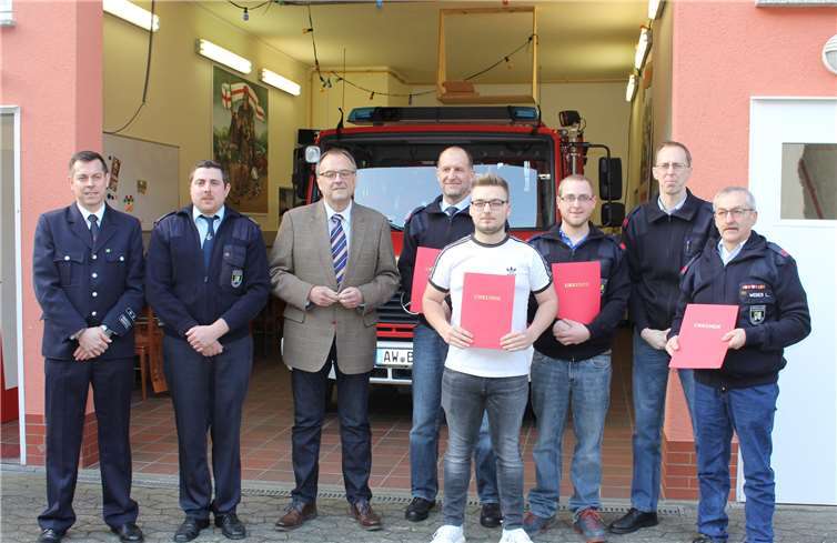 Wehrleiter Ronny Zilligen, Wehrführer Florian Braun und Bürgermeister Bernd Weidenbach mit den neu aufgenommenen und beförderten Feuerwehrkameraden.