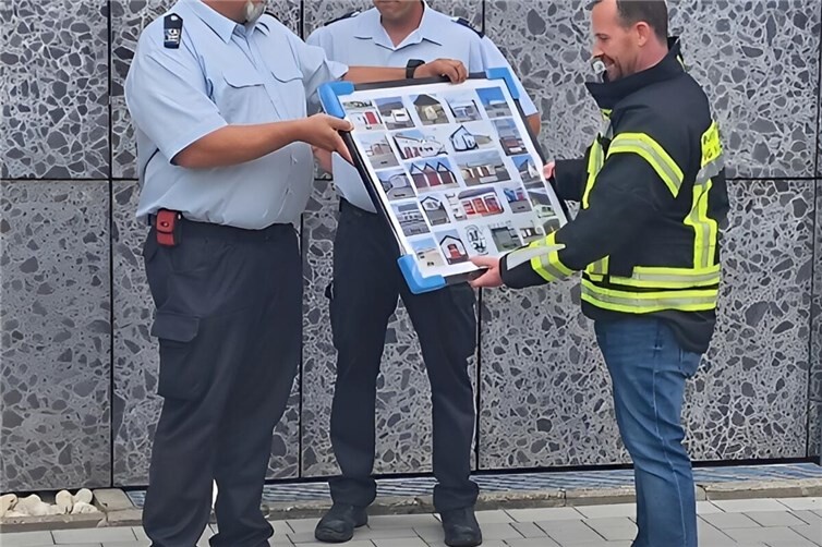 Wehrleiter Udo Mohr, sein Stellvertreter Tim Hepp und Bürgermeister Timo Kanzinger beim Überreichen der Foto-Collage 