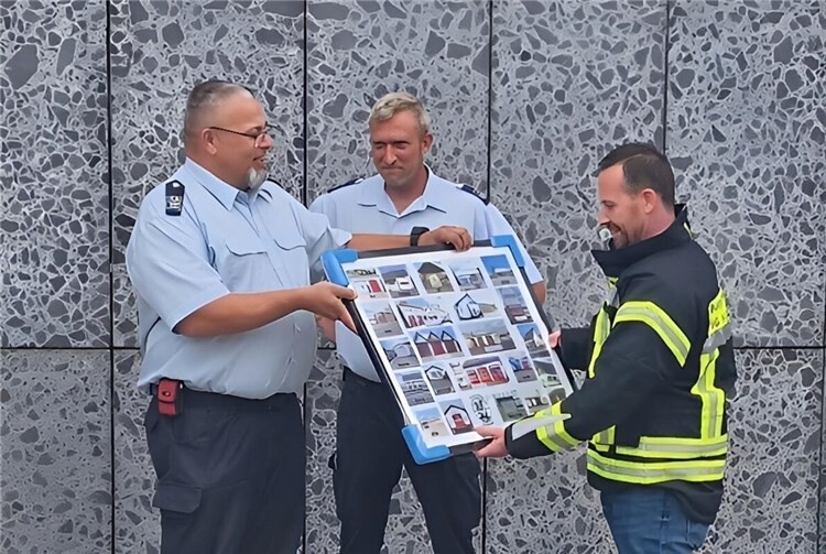 Wehrleiter Udo Mohr, sein Stellvertreter Tim Hepp und Bürgermeister Timo Kanzinger beim Überreichen der Foto-Collage.