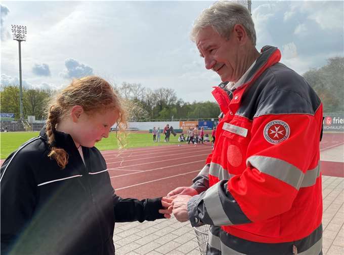 Wilfried Remy, ehrenamtlicher bei den Johannitern, versorgt eine Grundschülerin.  Foto: Martina Kollig