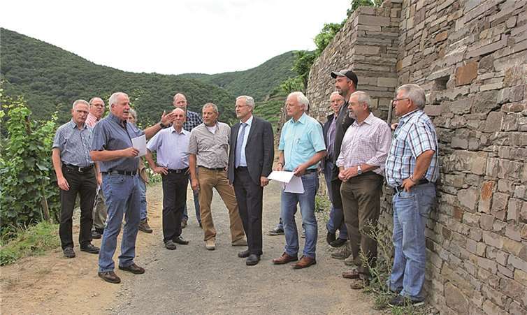 Willi Beu (3.v.l.), Vorsitzender der Teilnehmergesellschaft der Geländeeigentümer erläuterte vor Ort seinen Mitstreitern und dem Leiter der oberen Flurbereinigungsbehörde Martin Schumann (6.v.r.) die begonnene Maßnahme. BÜN