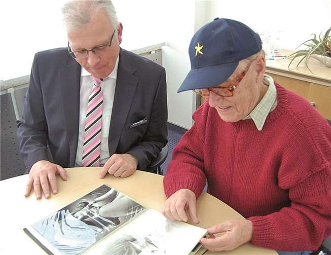 Willi Distelrath, Leiter der Bad Breisiger VoBa-Geschäftsstelle, lässt sich die Sammlung der berühmtesten Fotos von Jochen Meier erklären.