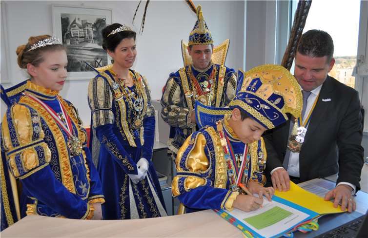 Willkommen in der Schaltzentrale des Rathauses, von links: Kinderprinzessin Lilly I, Prinzessin Sabrina I. Prinz Sven I, Kinderprinz Karim I., der die Amtsübernahme-Urkunde unterzeichnet, und Bürgermeister Holger Jung. Foto: Stadt Meckenheim