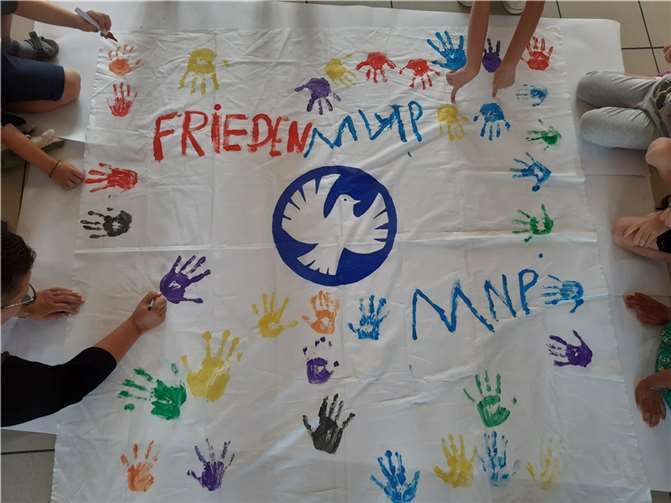 „Wir wollen Frieden für alle.“ Kinderhände besiegeln das Motto.  Foto: Sebastian Mählmann
