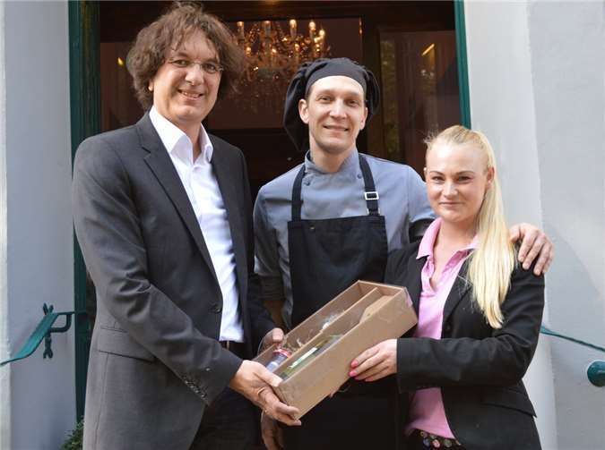 Wirtschaftsförderer Marc Bors (l.) überraschte das Gastwirtepaar vom Restaurant „Alte Rebe“ in Remagener am Marktplatz, Tanja Wolff und Michael Kröner, mit einem Wein und einem Weingelee von der Weinbaugemeinschaft Remagen. AB