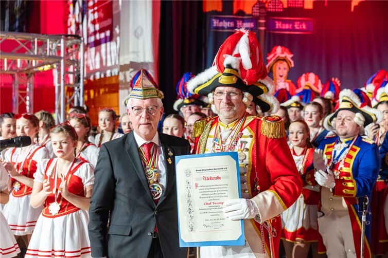 Wolfgang Bellinghausen vom Regionalverband Rhein Sieg des Bund Deuter Karneval überreicht Olaf Tramp die Urkunde zu dem Verdienstorden in Gold.  Foto: dietmarwalter|photography