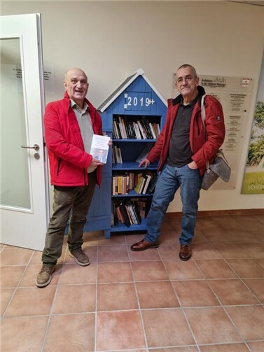 Wolfgang Hürter (links), Vorsitzender des Freundeskreises Linz Pornic, und Ralph Müller (rechts), stellvertretender Vorsitzender, am neu bestückten Bücherschrank im Scherer Shopping Center.  Foto: privat