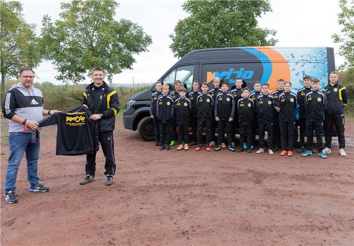 Wolfgang Kriechel (l.) von der Firma WIJA übergibt die Trainingsanzüge an Andreas Bauer und das GSG-U15-Team. Foto: privat