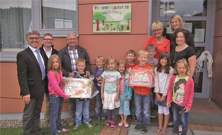 Wolfgang Kroeger, Carsten Lohre, Wolfgang Kistner, Hannelore Ockenfels, Melanie Peters und Melanie Nelles (v.li.) freuen sich mit den Kindern über den neuen Namen „Kindertagesstätte Hellenbach“. privat