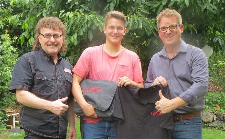 Wolfgang (Matt) Degen und Carsten Müller überreichen Tim Schommer Chortasche und Chorshirt des MC Plaidt.Foto: MC Plaidt