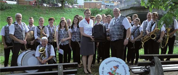 Wolfgang Mönch nimmt stellvertretend für die Mitglieder des Blasorchesters Altenahr neue Notenrucksäcke von Kerstin Holzberger, Leiterin der KSK-Geschäftsstelle in Altenahr, in Empfang.