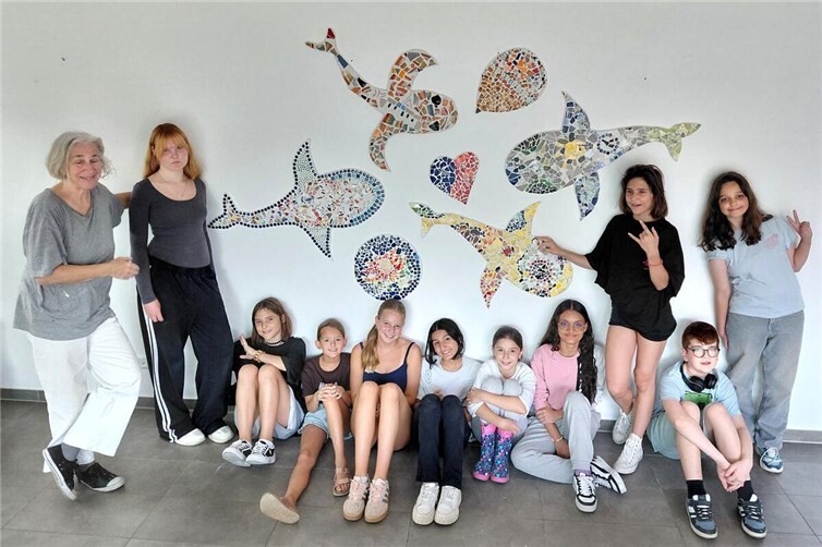 Workshop-Leiterin beate maria wörz und die Teilnehmenden mit dem gemeinsamen Kunstwerk