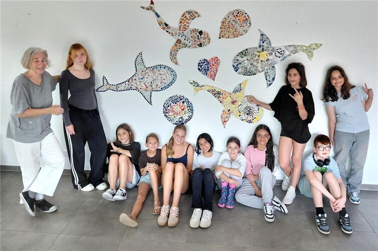 Workshop-Leiterin beate maria wörz und die Teilnehmenden mit dem gemeinsamen Kunstwerk.