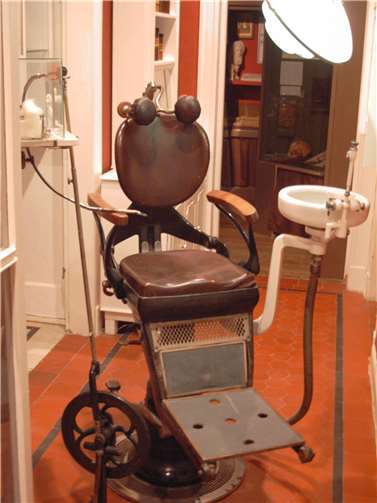 Zahnarztstuhl und Tretbohrer aus der Zeit um 1910.