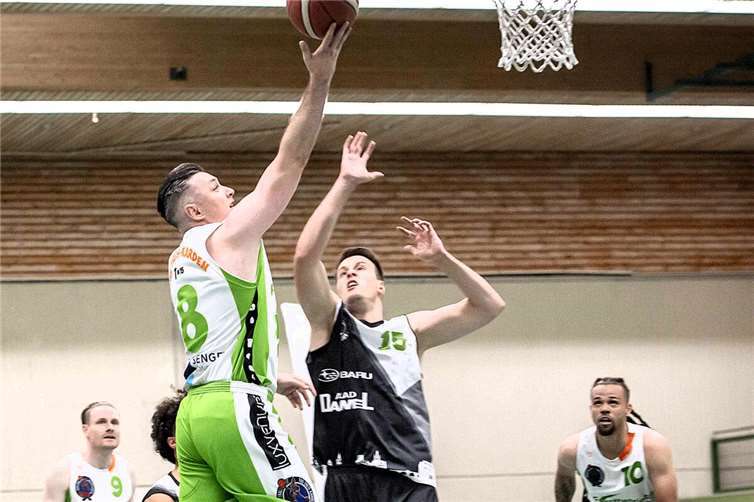 Zeljko Novak vom TuS Treis-Karden (in grün-weiß) beim erfolgreichen Korbleger, links Alex Zilles (Nr.9) und rechts mit der Nr. 10 Dylan West  Foto: Lisa Ferrlein