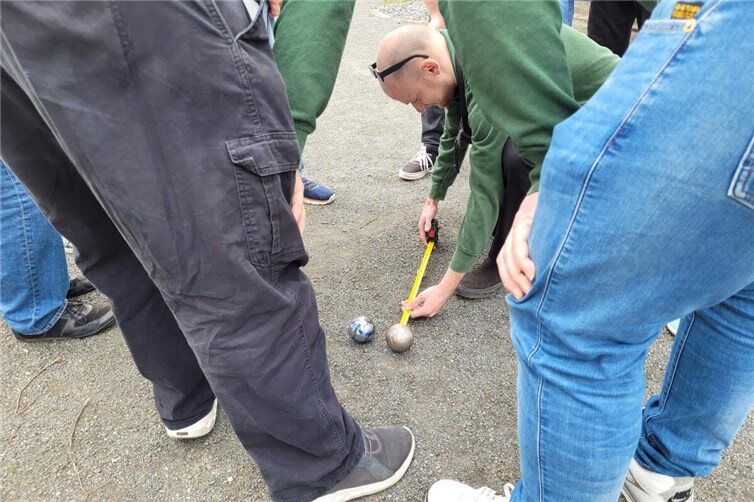 Zentimeterarbeit beim Boule: Mit Maßband wurde genau geprüft, welche Kugel am nächsten am Ziel liegt.