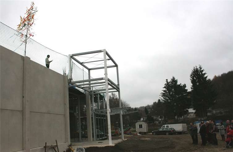 Zimmermannsmeister Lothar Rosenbaum sprach den Richtspruch vom Dach des neuen Einkaufsmarktes.