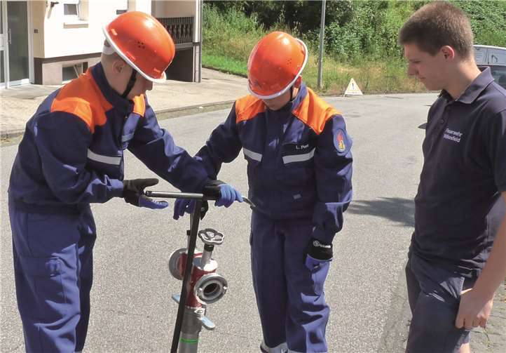Zu den Vorbereitungen des Löschangriffs wurde einem Hydranten mit Hilfe eines Standrohrs das Wasser entnommen und in Gang gesetzt.