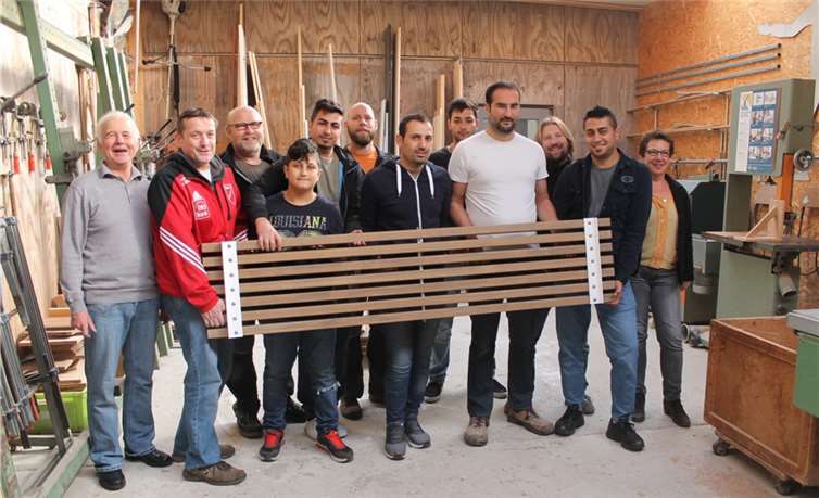 Zufrieden und sichtlich stolz präsentieren Djoar, Joan, Ahmad, Nameh und Ramsi die Bänke, die sie gemeinsam mit Schreinermeister Raimund Bayer für den Sportplatz des Rot Weiß Dünstekoven hergestellt haben.privat