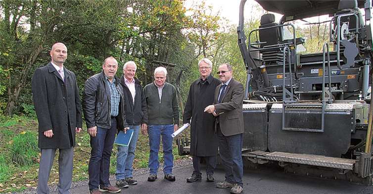 Zufriedene Gesichter aller beteiligten Akteure auf der noch warmen Tragdeckschicht der neuen Zufahrt zur Kläranlage.