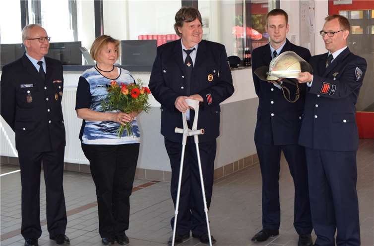 Die Feuerwehr feierte ihren Schutzpatron Zum Abschied aus dem aktiven Feuerwehrdienst überreichte Wehrführer Dirk Schwindenhammer (r.) Johannes Brengmann (Bildmitte) seinen ausgedienten Einsatzhelm mit Autogrammen der Kameradinnen und Kameraden.