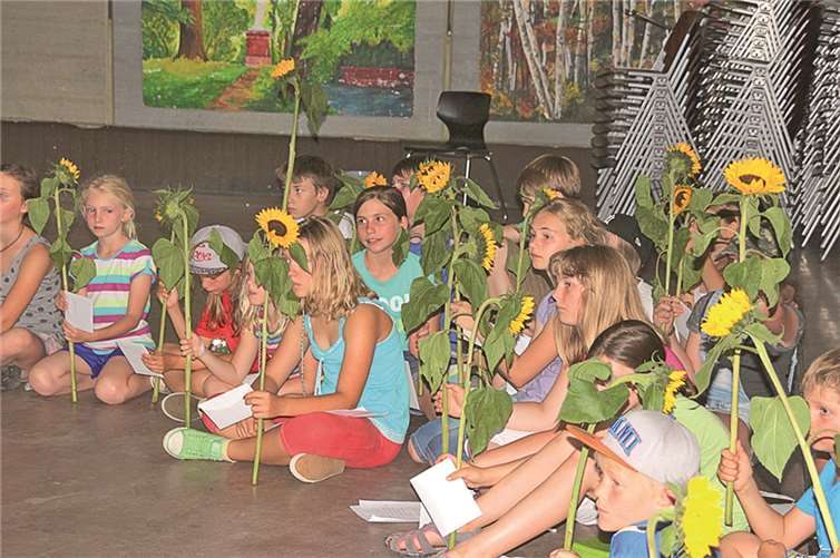 Zum Abschied überreichten die Kinder je eine Sonnenblume an ihre Betreuer.
