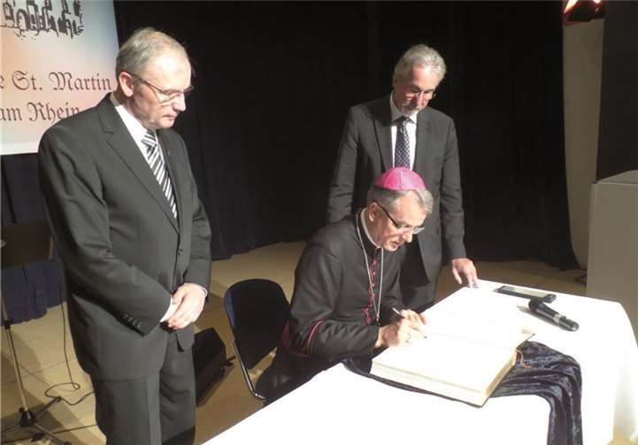 Zum Abschluss des Festaktes in der Stadthalle trug sich Weihbischof Jörg Michael Peters im Beisein von (l.) Pastor Klemens Hombach und (r.) Stadtbürgermeister Dr. Hans-Georg Faust in das Goldene Buch der Stadt und in das Gästebuch der St. Martin Kirche ein.STUKO1111111111111111