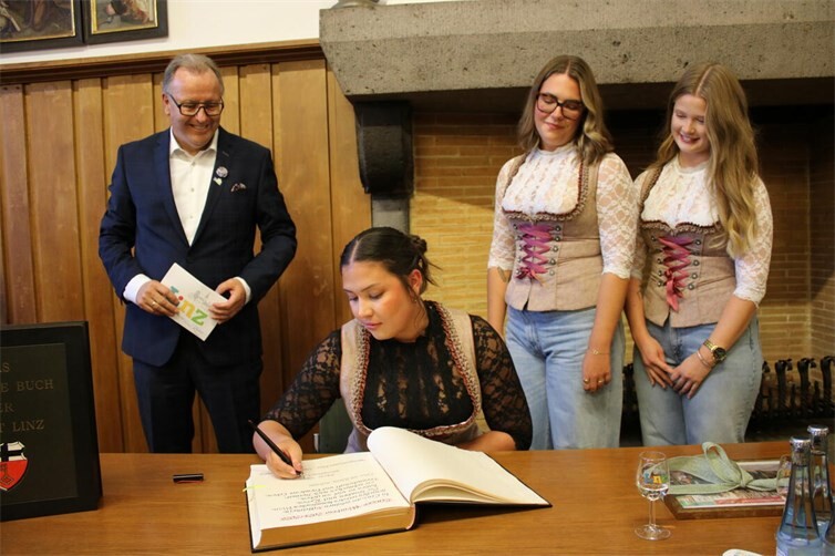 Zum Abschluss ihrer Amtszeit trägt sich Weinkönigin Antonia in das Goldene Buch der Stadt Linz am Rhein ein. Begleitet wird sie von den Weinprinzessinnen Nina und Sophie sowie Stadtbürgermeister Helmut Muthers.