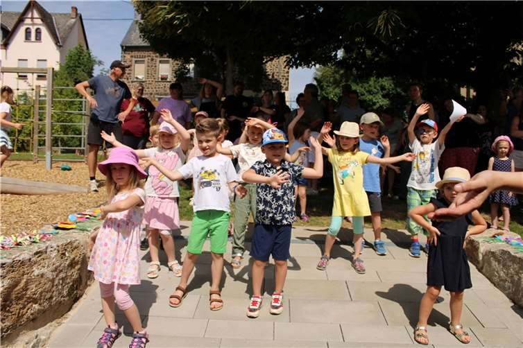 Zum Fliegerlied tanzten die Kinder und luden Eltern, Großeltern, Tanten, Onkel, geladenen Gäste, Trägervertreter und den Verbandsgemeindebürgermeister ein mitzumachen. Foto: Isabel de Castro