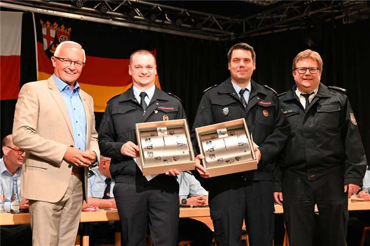 Zum Jubiläum überreichten Landrat Achim Hallerbach und BKI Holger Kurz ein Präsent an die Feuerwehren Bad Hönningen und Rheinbrohl-Hammerstein. Foto: Lemgen – FW VG Bad Hönningen