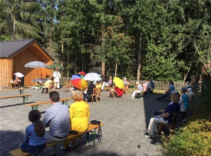 Zum Schutz gegen die Sonne hatten einige Besucher sich Schirme mitgebracht. So konnten sie den Gottesdienst genießen. Foto: privat