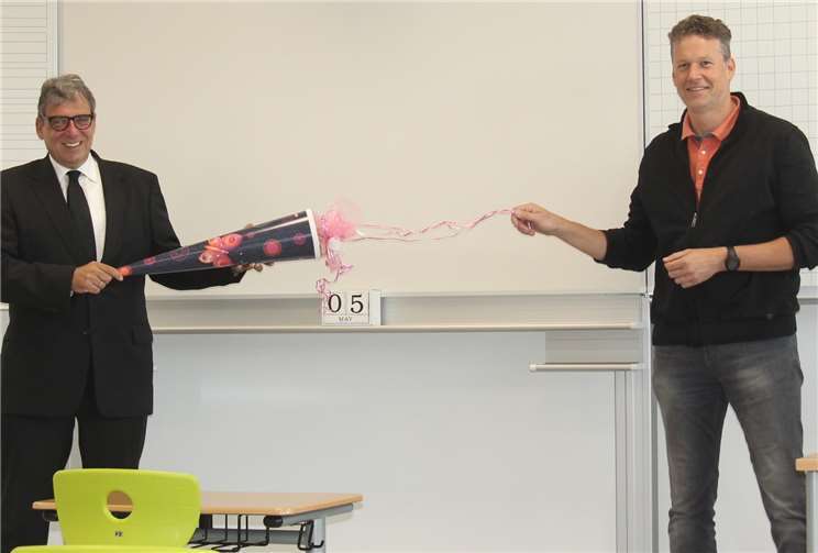 Zum ersten Schultag in der neuen Waldschule brachte Andree Stein (l.) eine Schultüte gefüllt mit Naschereien für die Viertklässler und das Kollegium mit. Mit gebührendem Abstand nahm Schulleiter Stefan Gleis das Geschenk entgegen.Foto: privat