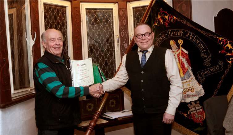 Zunftmeister Bernd Koll überreicht Franz Webereine Urkunde für 45 Jahre in der Wollenweber Zunft.